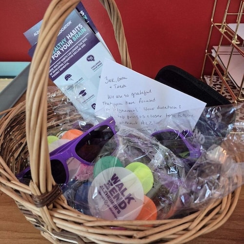 Gift basket with Alzheimer’s Association materials, purple sunglasses, Walk to End Alzheimer’s swag, and a thank-you note to the GSMS team.