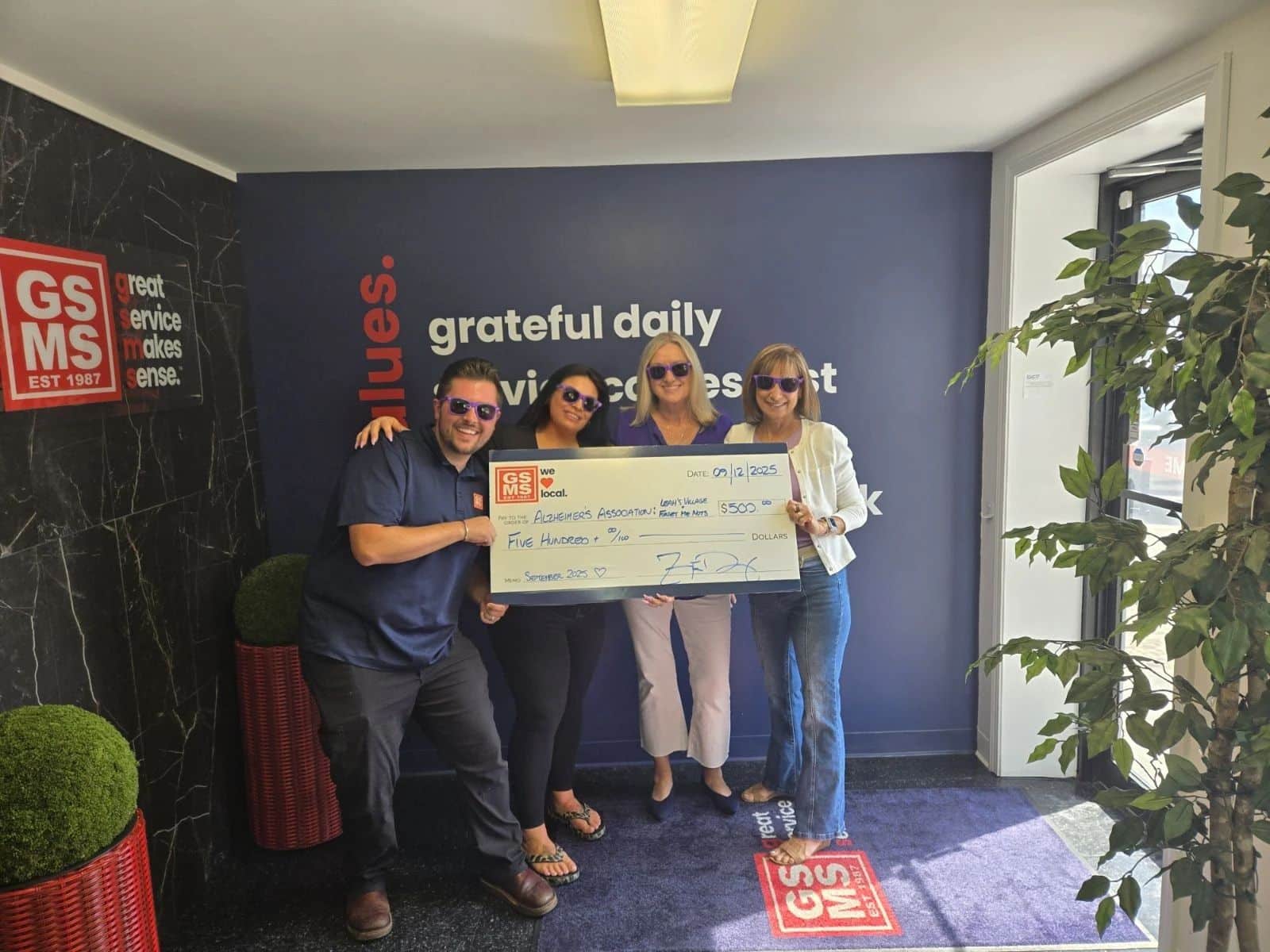GSMS team presenting a $500 donation check to the Alzheimer’s Association in support of families impacted by Alzheimer’s disease.