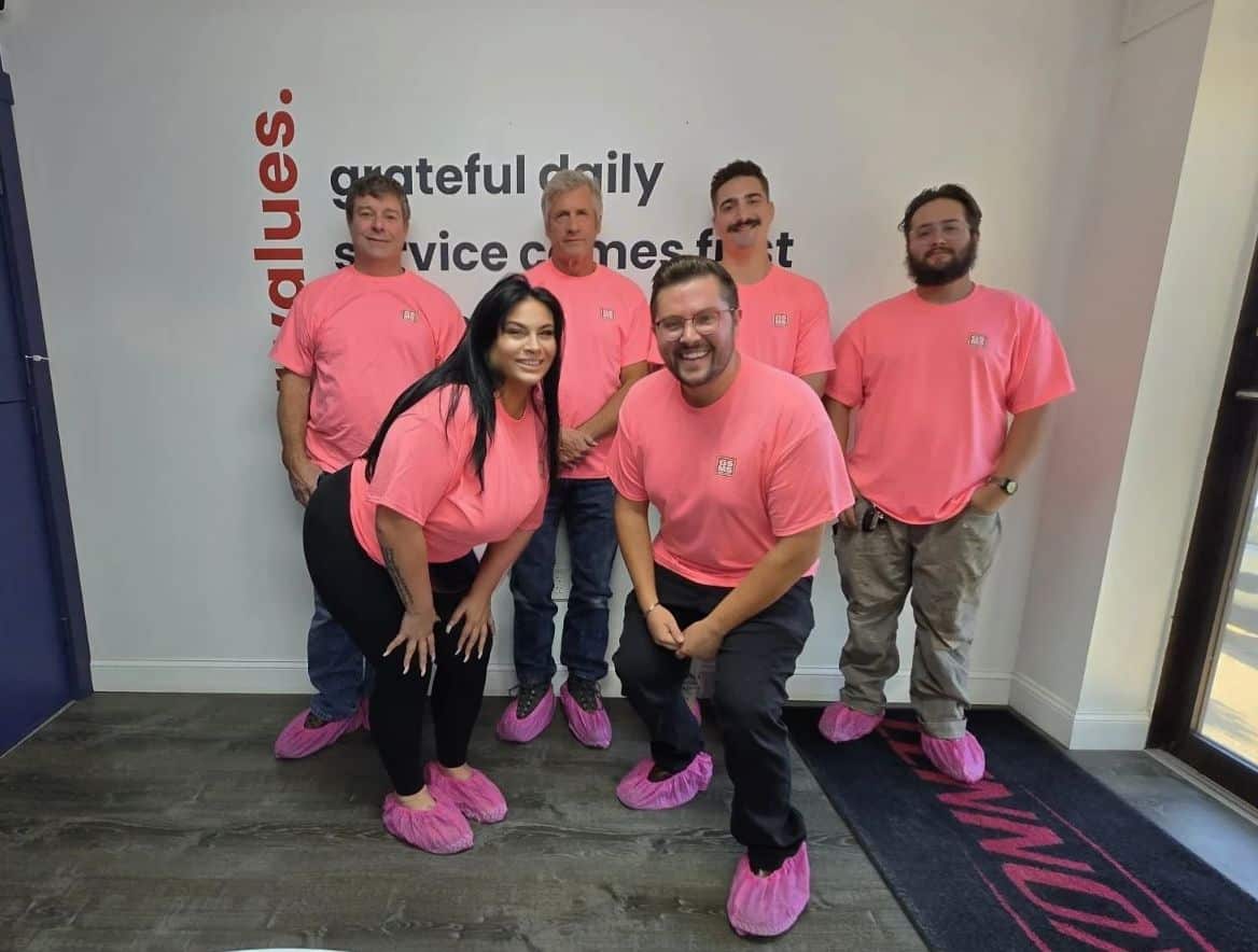GSMS team wearing bright pink shirts and shoe covers to support the Men Wear Pink campaign for breast cancer awareness.
