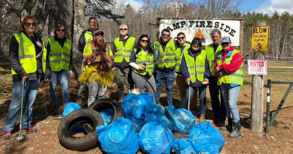 GSMS team volunteers with Don’t Trash Barrington during a community litter clean-up, standing with collected trash bags and tires in Barrington, NH.