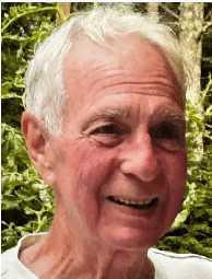 Portrait of Jude Charpentier smiling outdoors, surrounded by greenery.